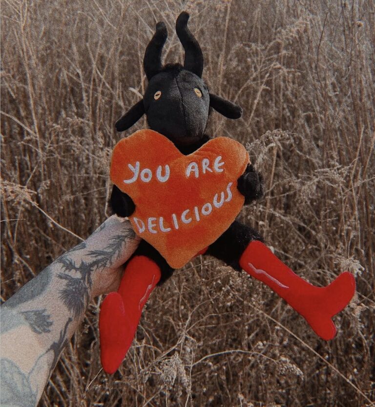 Black horned plush character holding an orange heart that reads You Are Delicious