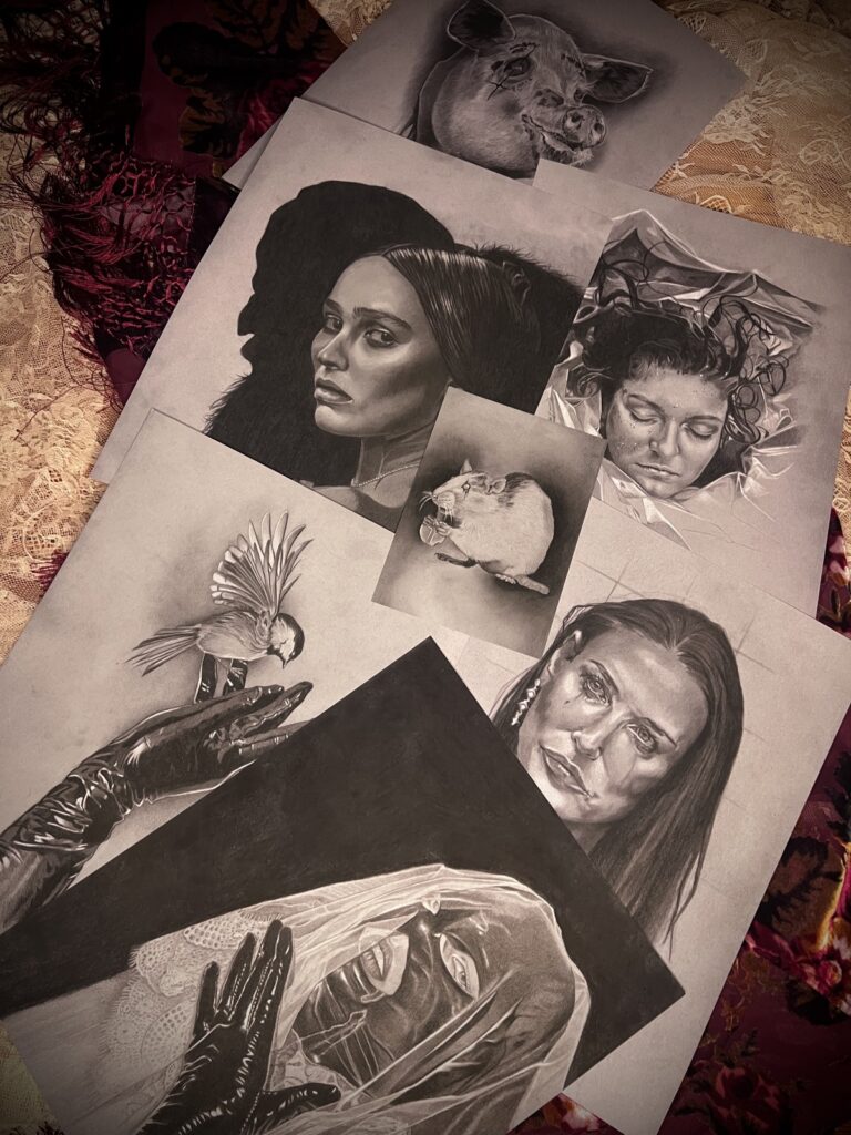 Monochrome portraits and animal art prints arranged on patterned fabric