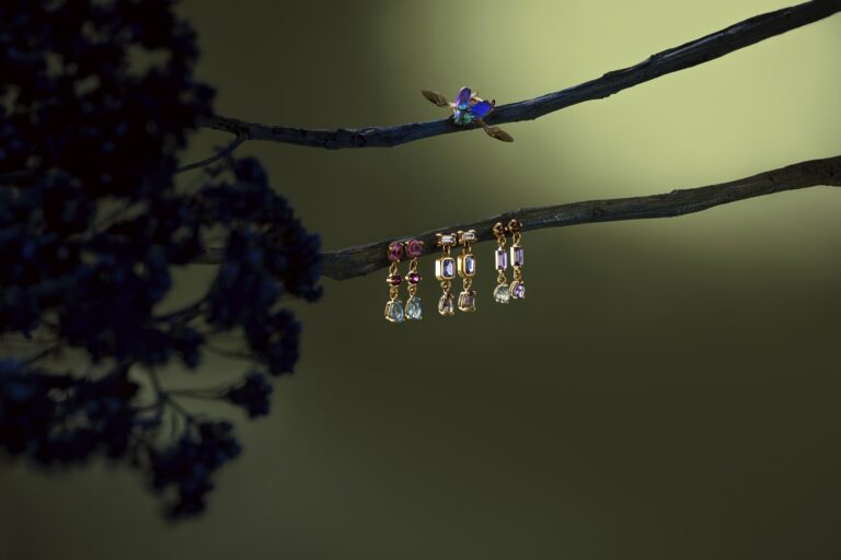 Jenni Stuart Fine Jewelry — articulated multi-gemstone earrings beneath a jewel-colored beetle