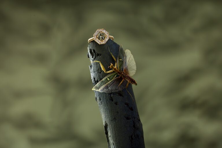 Jenni Stuart Fine Jewelry — vintage-inspired green sapphire and diamond ring on a branch above a winged insect