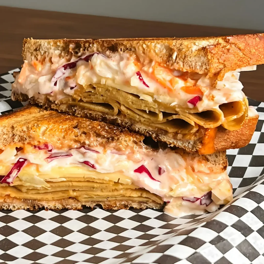 Two halves of a vegan sandwich with slaw on checkered paper at Not Ya Mama’s.