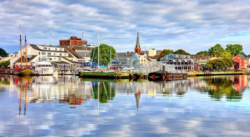 Boats and waterfront buildings reflected in Salem Harbor at Pickering Wharf.