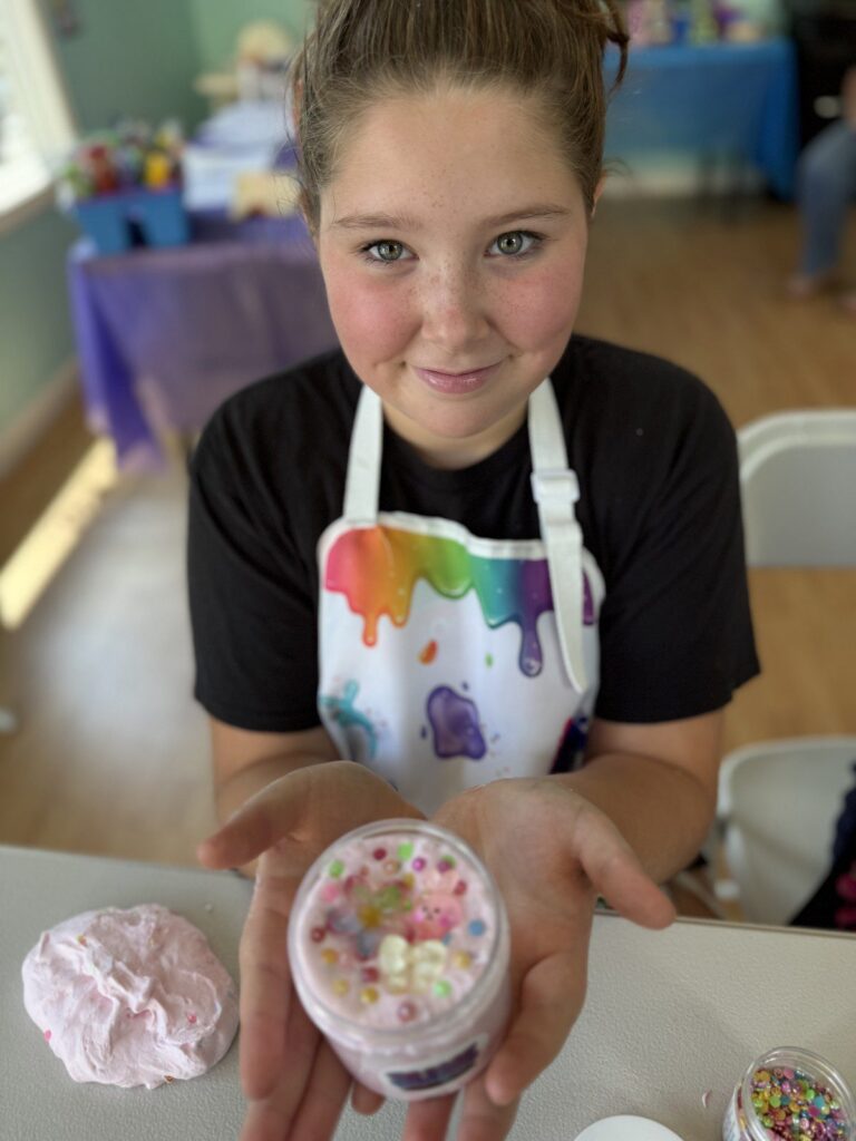 Participant holding a slime creation at the studio