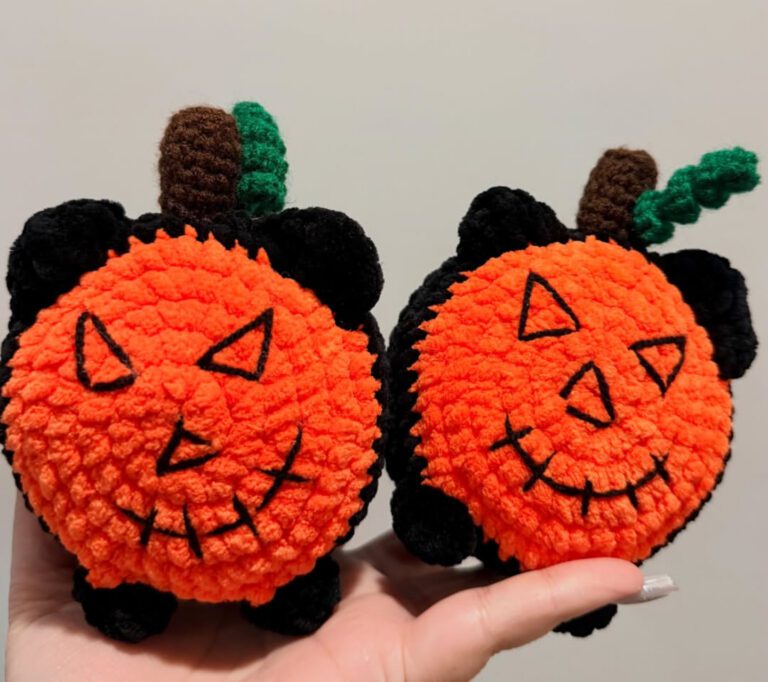Two orange-and-black pumpkin-kitty crochet plush figures by Ari’s Crochet