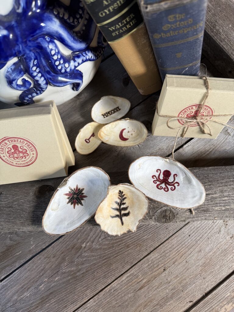 Hand-painted shell talismans with botanical, moon and sea-life designs. Hand-painted shell talismans with botanical, moon and sea-life designs.